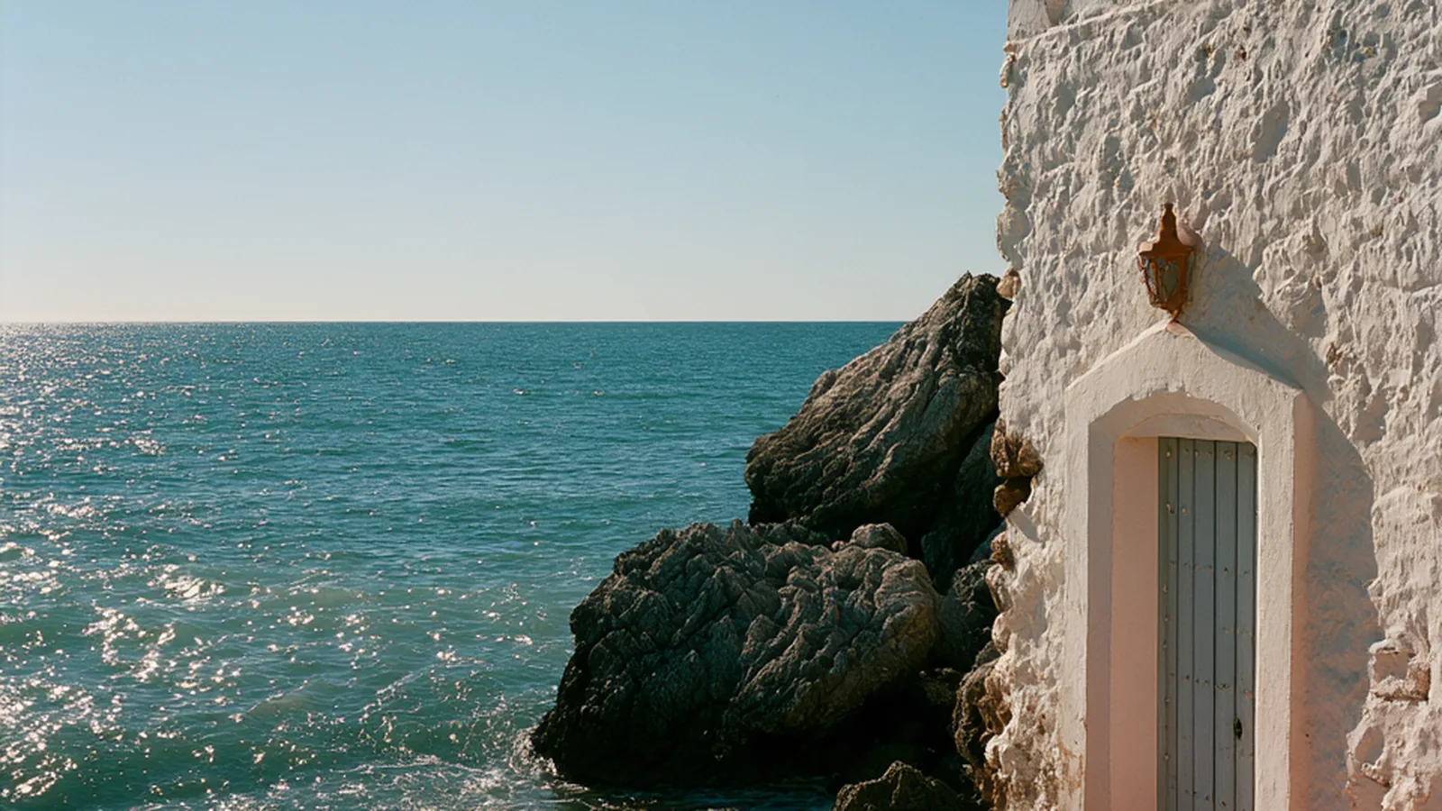 Whitewashed wall and doorway above the Mediterranean